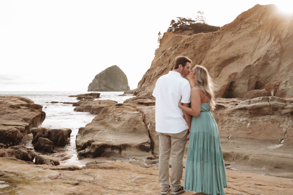 couple kissing at Cape Kiwanda during engagement photos in Oregon