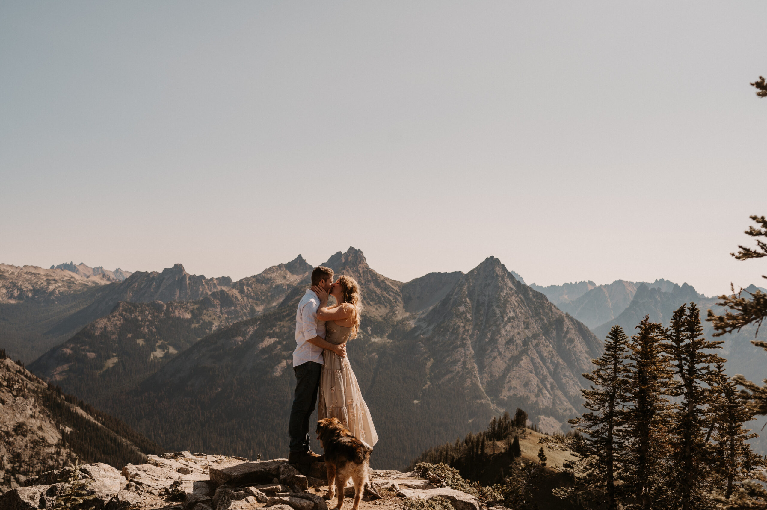 couple embraces on mountaintop in north cascades national park after surprise proposal