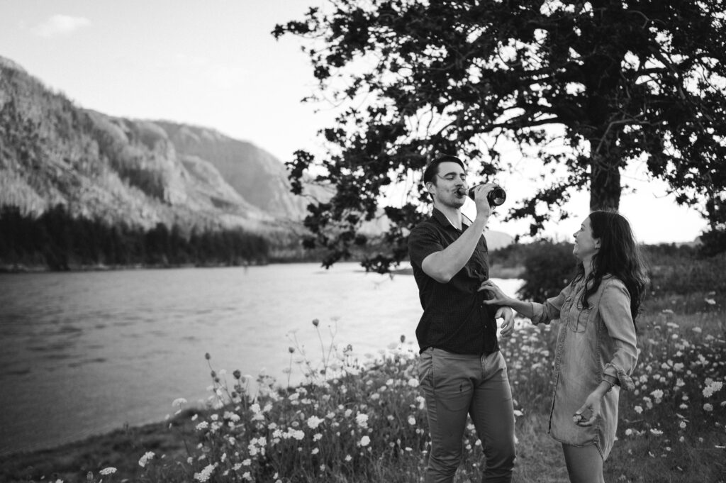 couple drinking champagne in Columbia River Gorge for engagement photos 