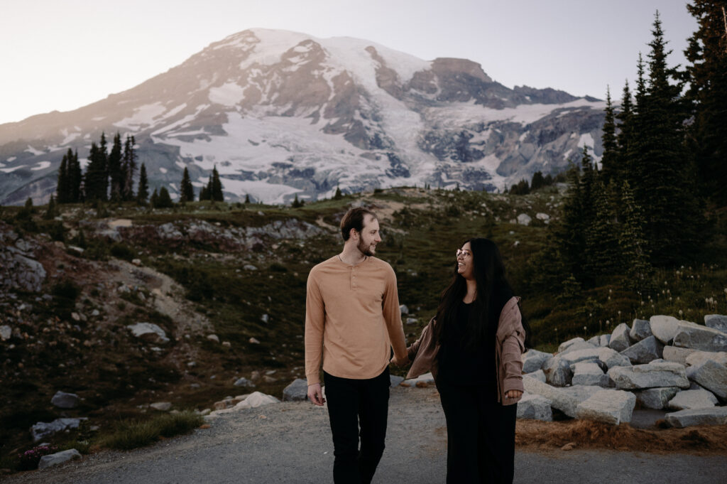 couple walking in front of Mount Rainier during engagement photos