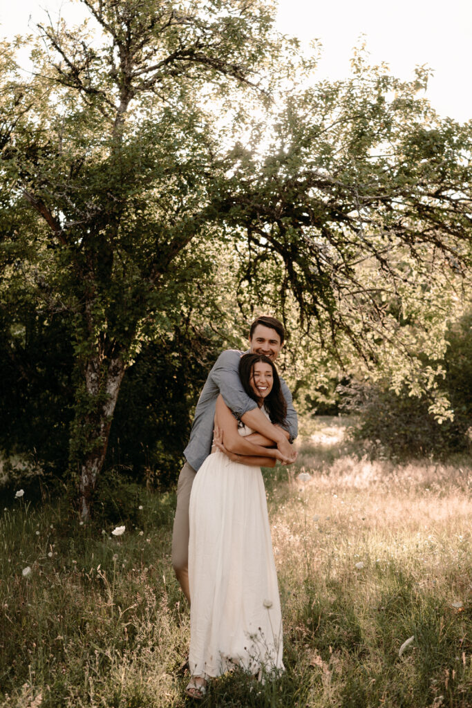 couple smiles and laughs together during engagement session
