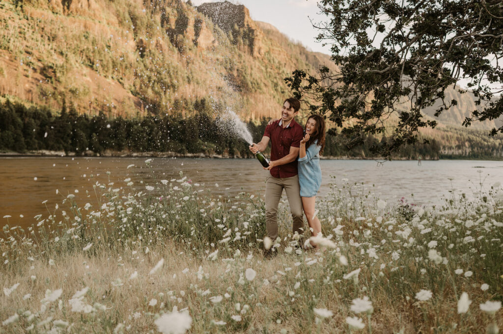 couple spraying champagne in columbia river gorge