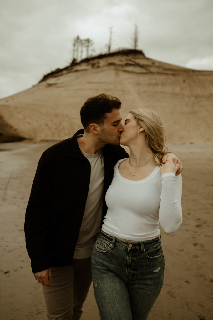 couple kissing in pacific city during their oregon coast engagement session