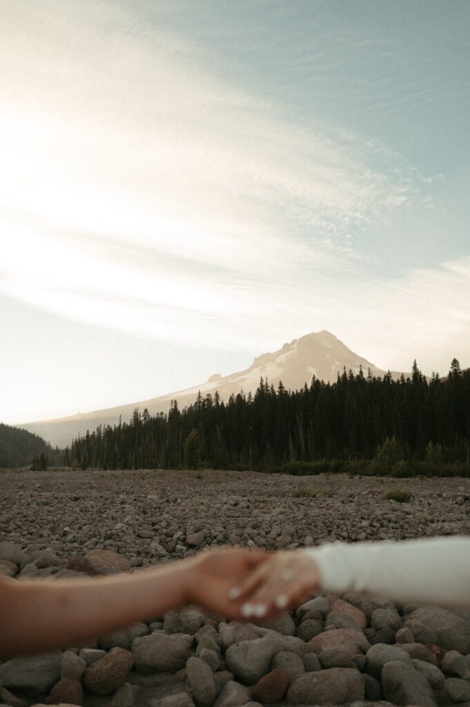 mount hood in the background of hands and engagement ring