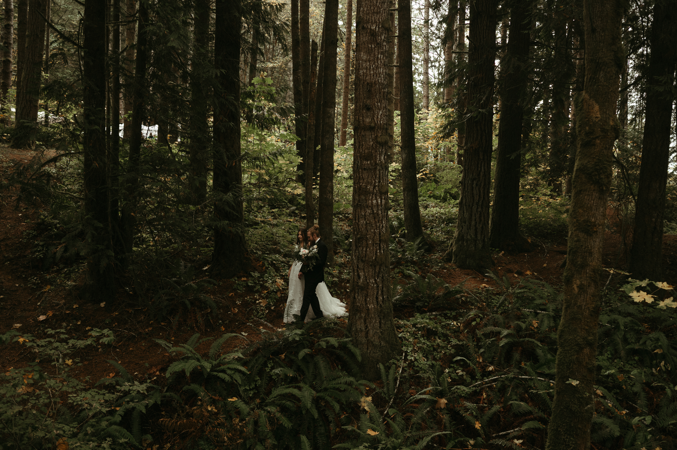 couple walking in woods after wedding ceremony