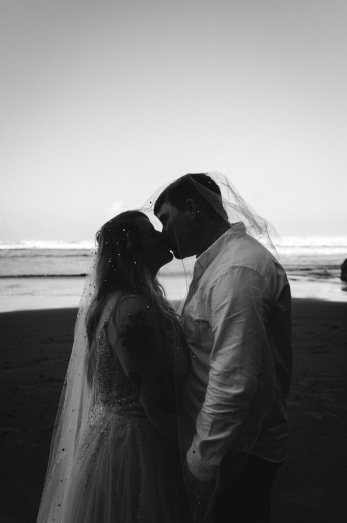 couple under veil during oregon coast elopement