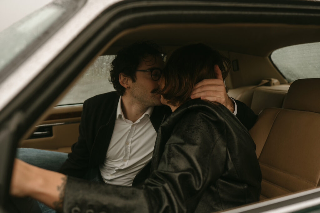 couple kissing in vintage jaguar during oregon coast couples session