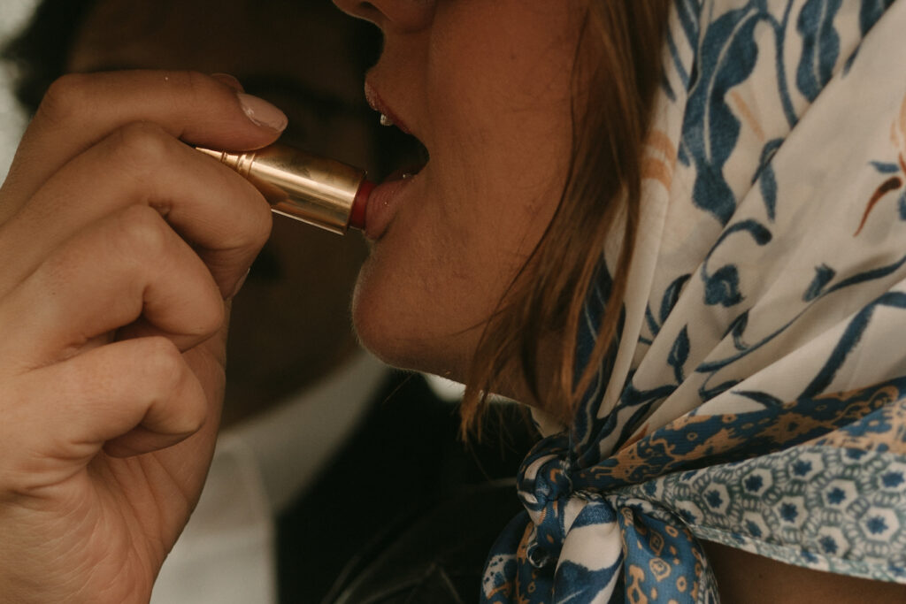 woman putting on lipstick