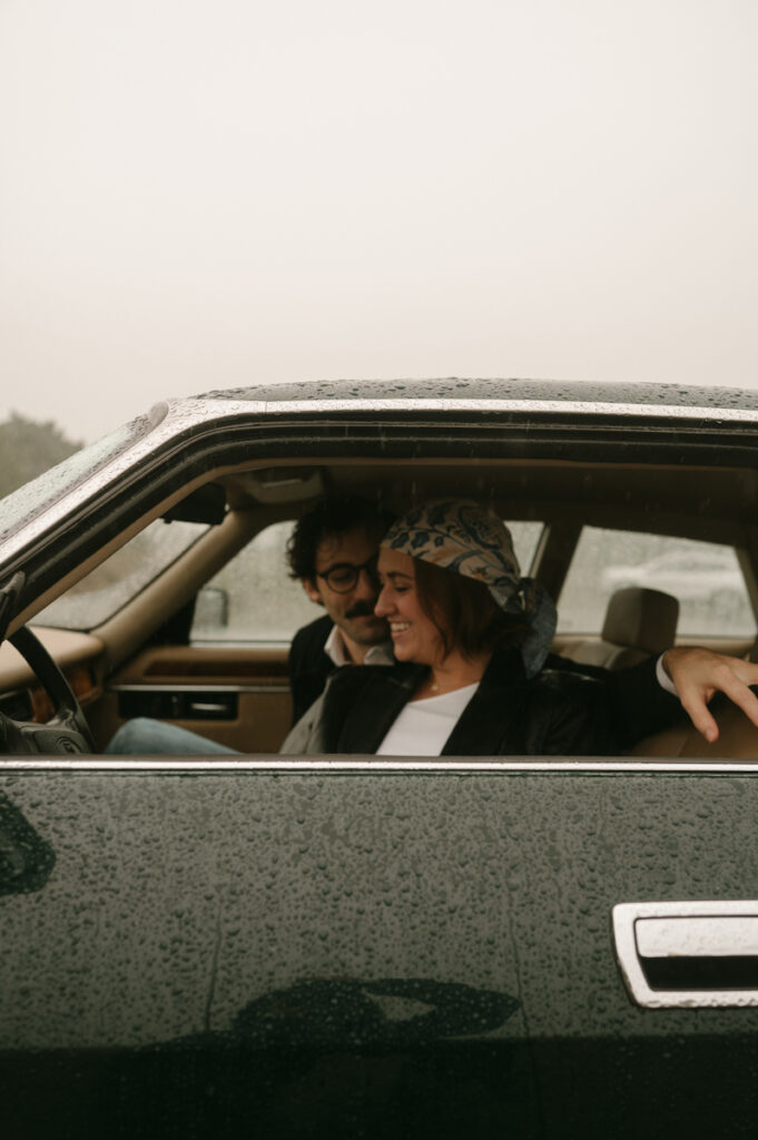 couple laughing in classic jaguar during oregon coast couples session