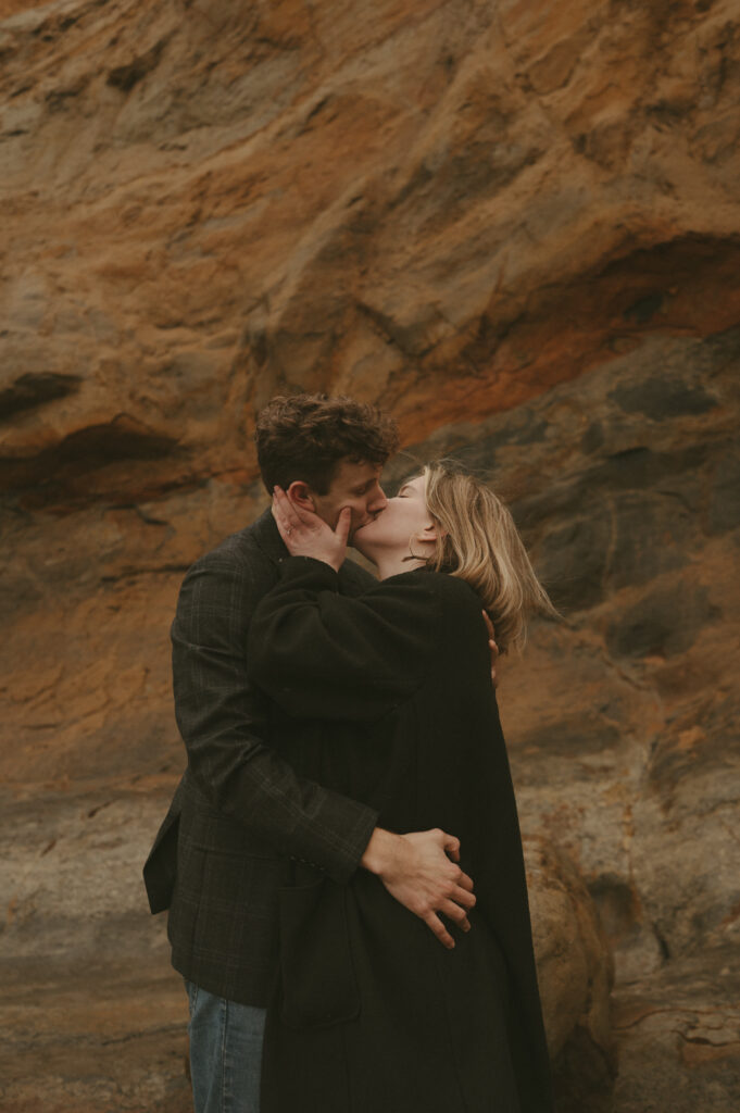 couple kissing during oregon coast engagement session