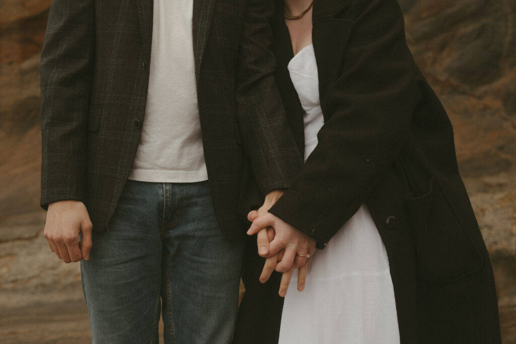 couple holding hands during oregon coast engagement session