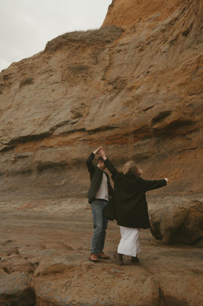 couple dancing on rocks at Cape Kiwanda