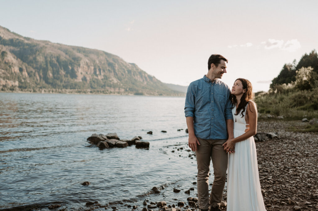 Couple leans in together on the Columbia River during their sunset engagement photo session