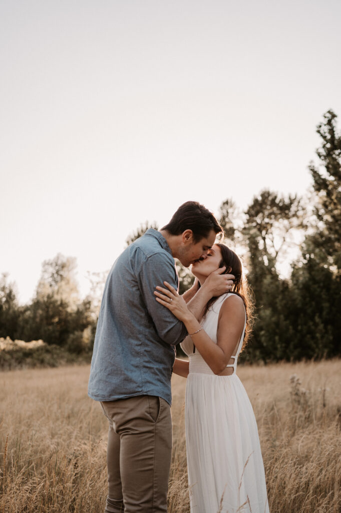 couple kisses in golden hour engagement session