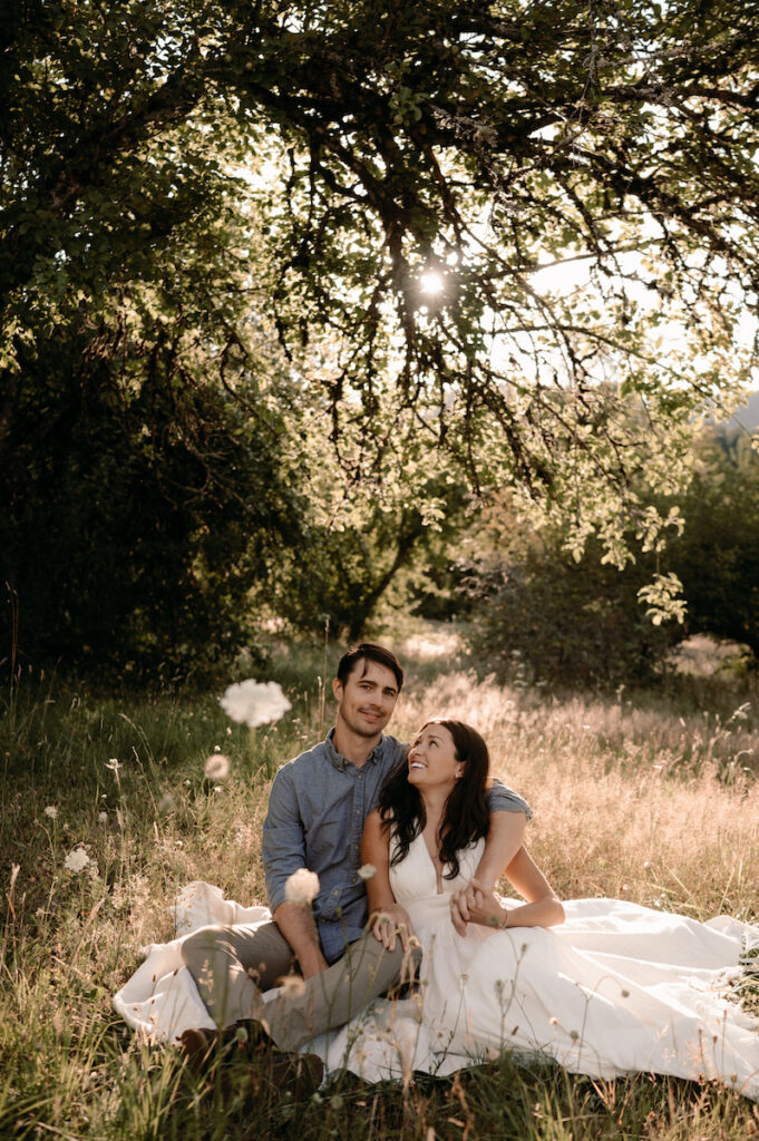 couple sits next to each other on blanket during engagement photos