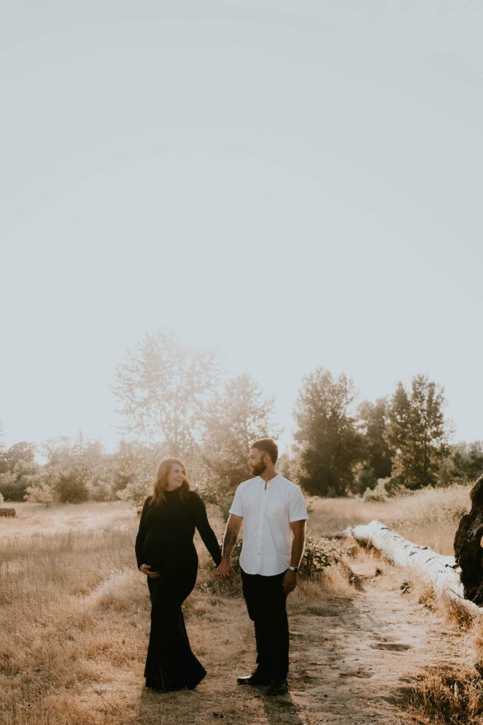 husband and wife hold hands during Oregon maternity session